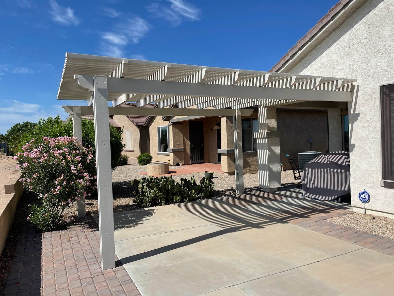 Outdoor living space with shade and fire features by AZ Pool Concepts in Phoenix
